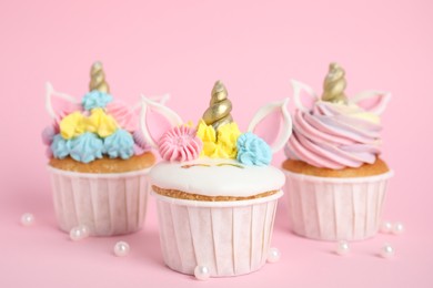 Cute sweet unicorn cupcakes on pink background