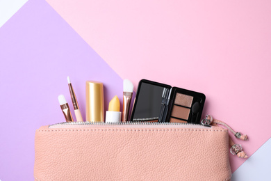 Photo of Bag with hygienic lipsticks and cosmetic products on color background, flat lay. Space for text