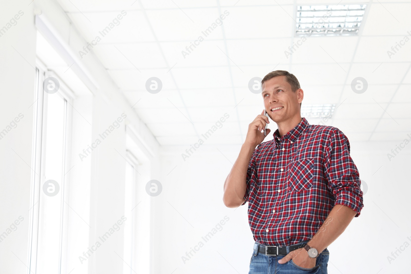 Photo of Young man talking on phone in office. Time to work