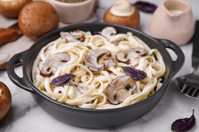 Photo of Delicious pasta with mushrooms on white marble table, closeup