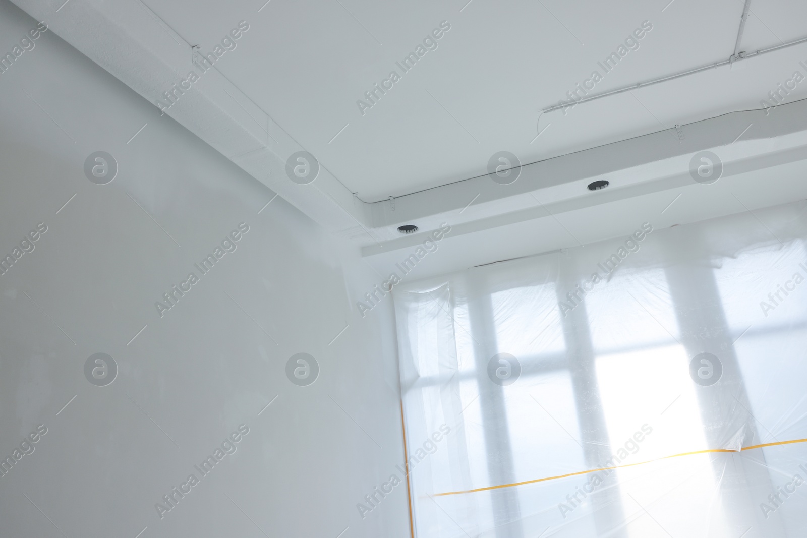 Photo of Big windows covered with plastic film indoors
