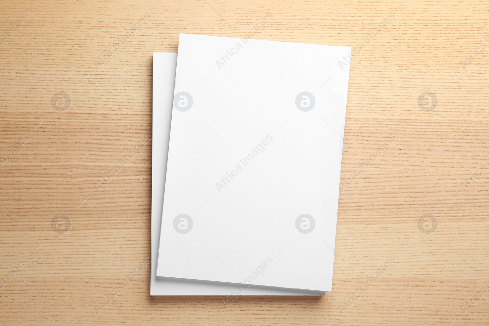 Photo of Stack of blank paper sheets for brochure on wooden background, top view. Mock up