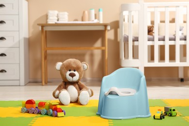 Photo of Light blue baby potty and toys in room. Toilet training