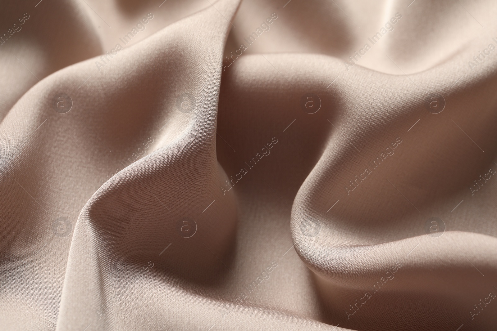 Photo of Texture of beige crumpled silk fabric as background, closeup