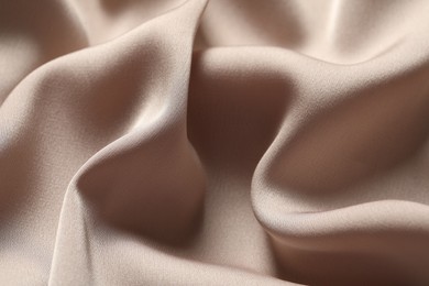 Texture of beige crumpled silk fabric as background, closeup