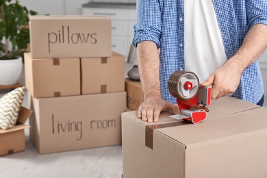 Photo of Man packing moving box indoors, closeup. Space for text