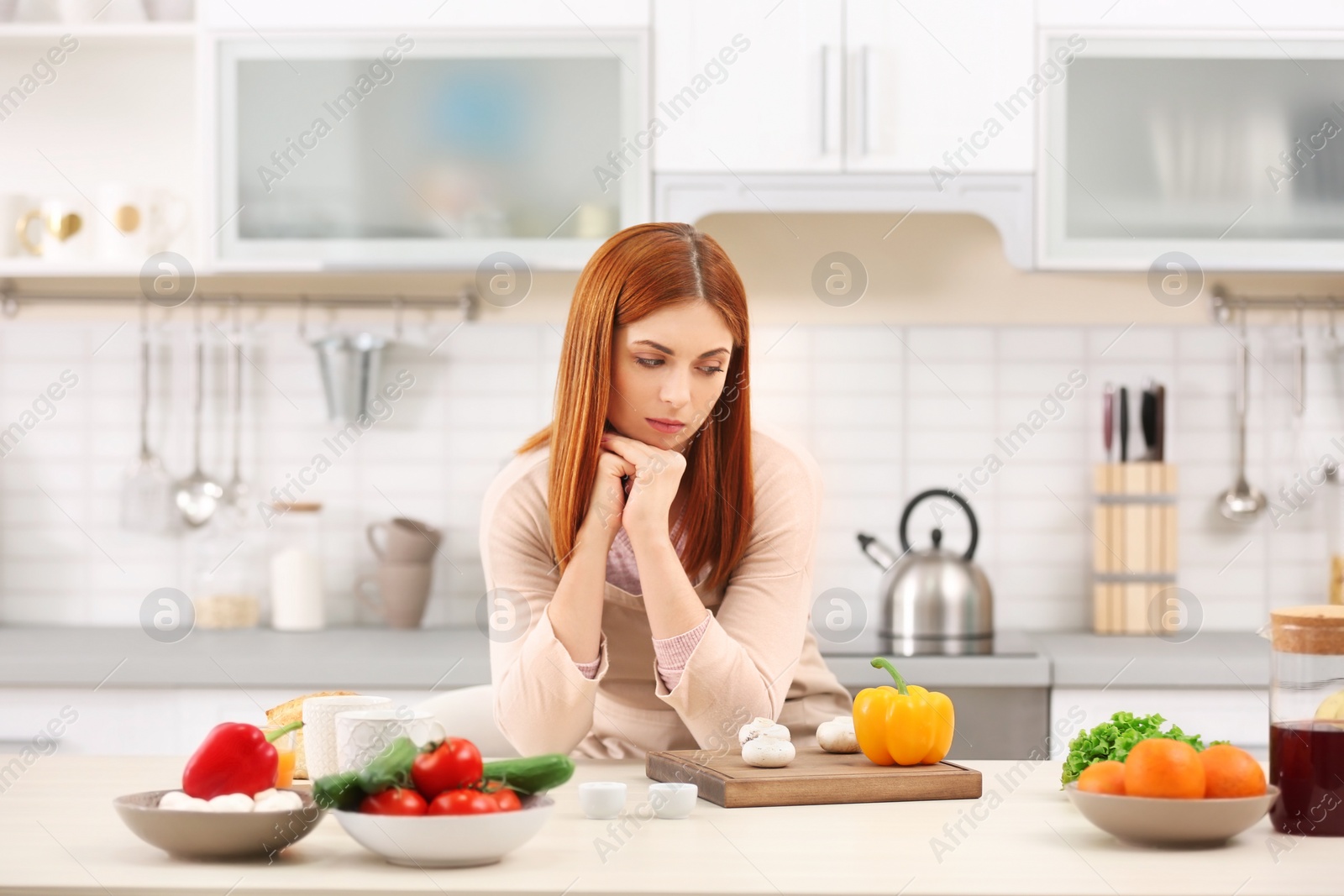 Photo of Tired housewife cooking in kitchen