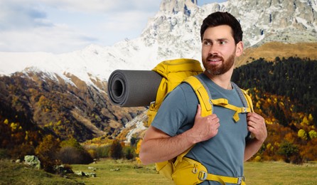 Image of Happy tourist with yellow backpack in mountains