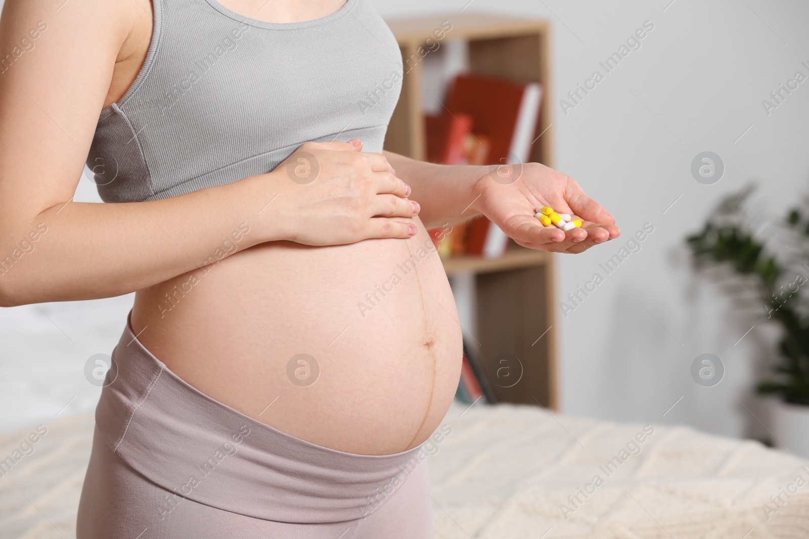 Photo of Pregnant woman taking pills at home, closeup