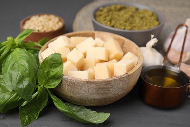 Different ingredients for cooking tasty pesto sauce on grey table, closeup