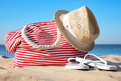 Photo of Set with stylish beach accessories on sand near sea