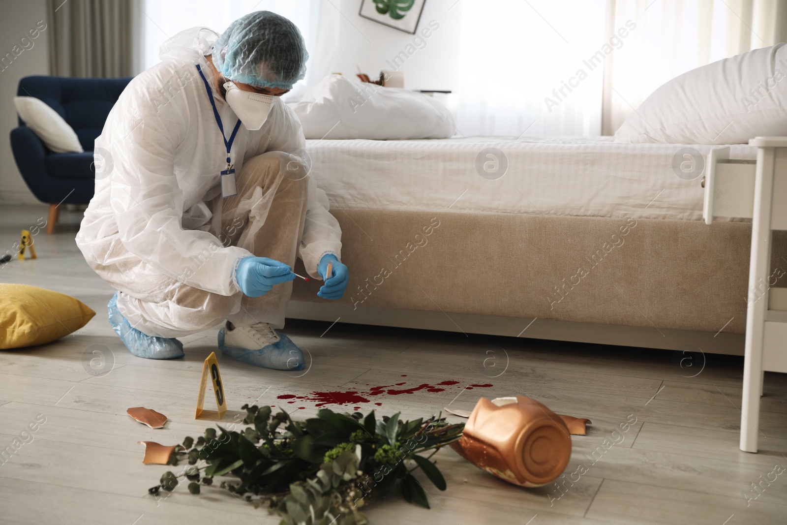 Photo of Investigator in protective suit working with blood sample at crime scene