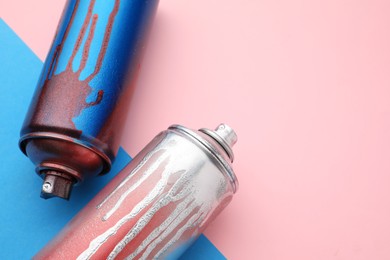 Photo of Used cans of spray paints on color background, above view with space for text. Graffiti supplies
