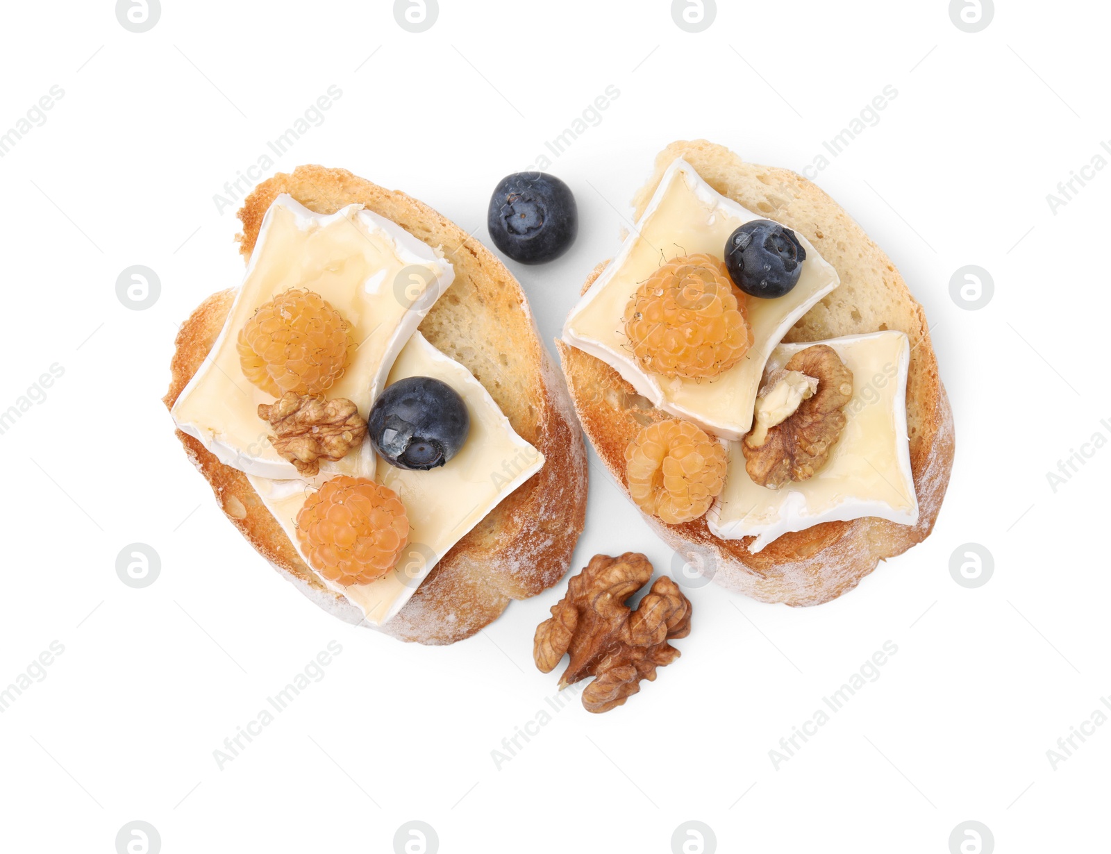 Photo of Tasty sandwiches with brie cheese, fresh berries and walnuts isolated on white, top view