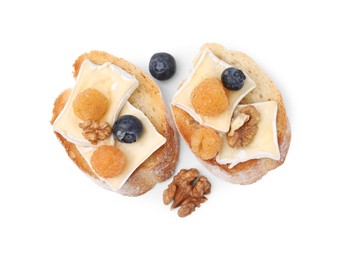 Tasty sandwiches with brie cheese, fresh berries and walnuts isolated on white, top view