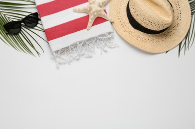 Photo of Beach towel, straw hat and sunglasses on light background, flat lay. Space for text