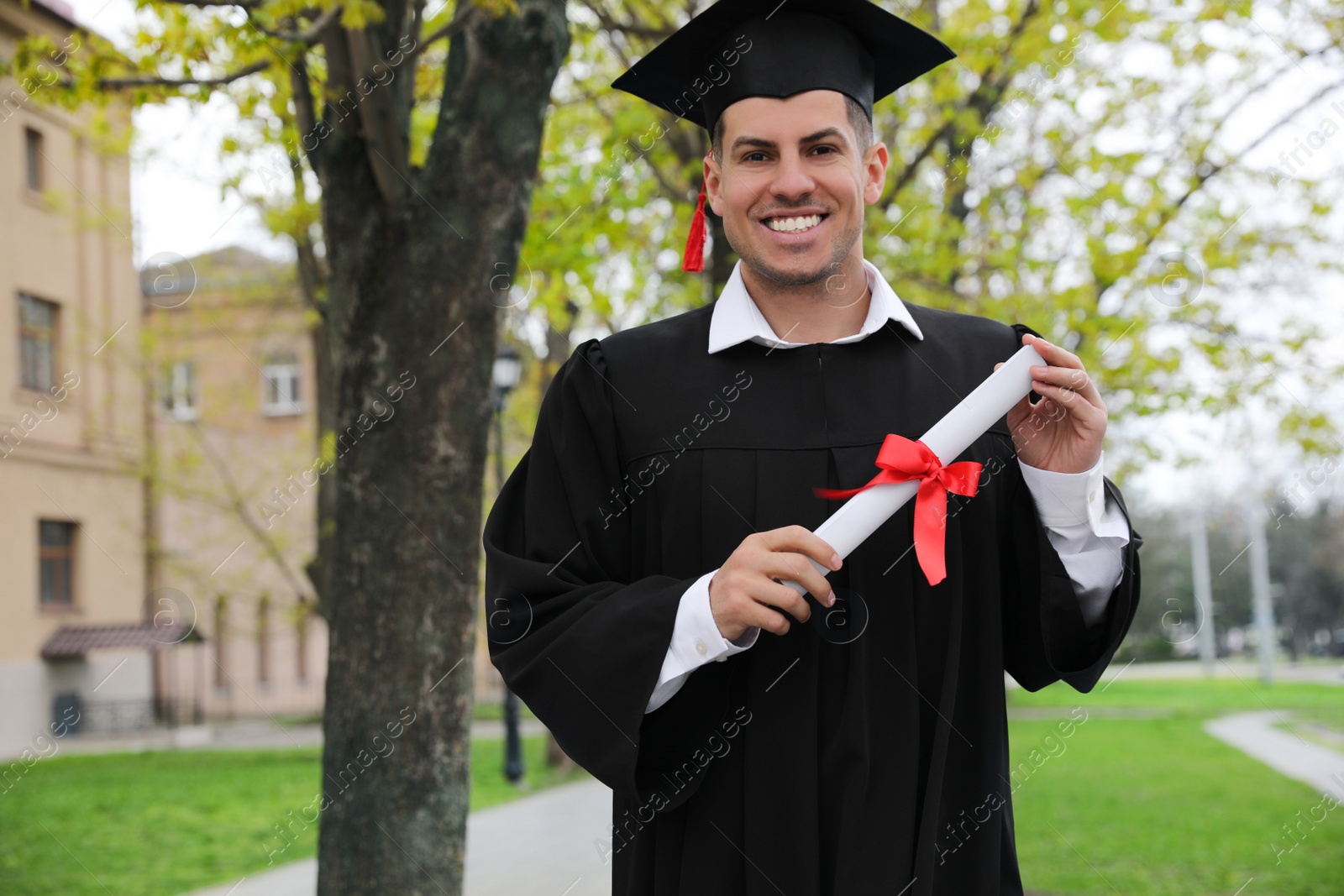 Photo of Happy student with diploma after graduation ceremony outdoors. Space for text