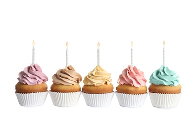 Delicious birthday cupcakes with candles on white background