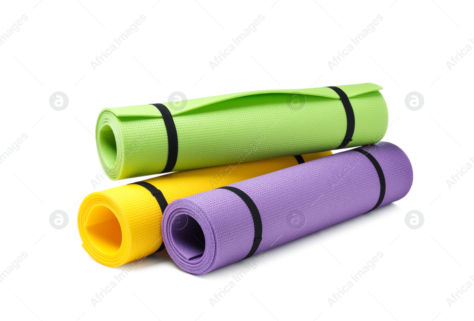 Photo of Colorful rolled camping or exercise mats on white background