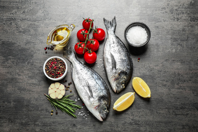 Photo of Flat lay composition with raw dorada fish on grey table