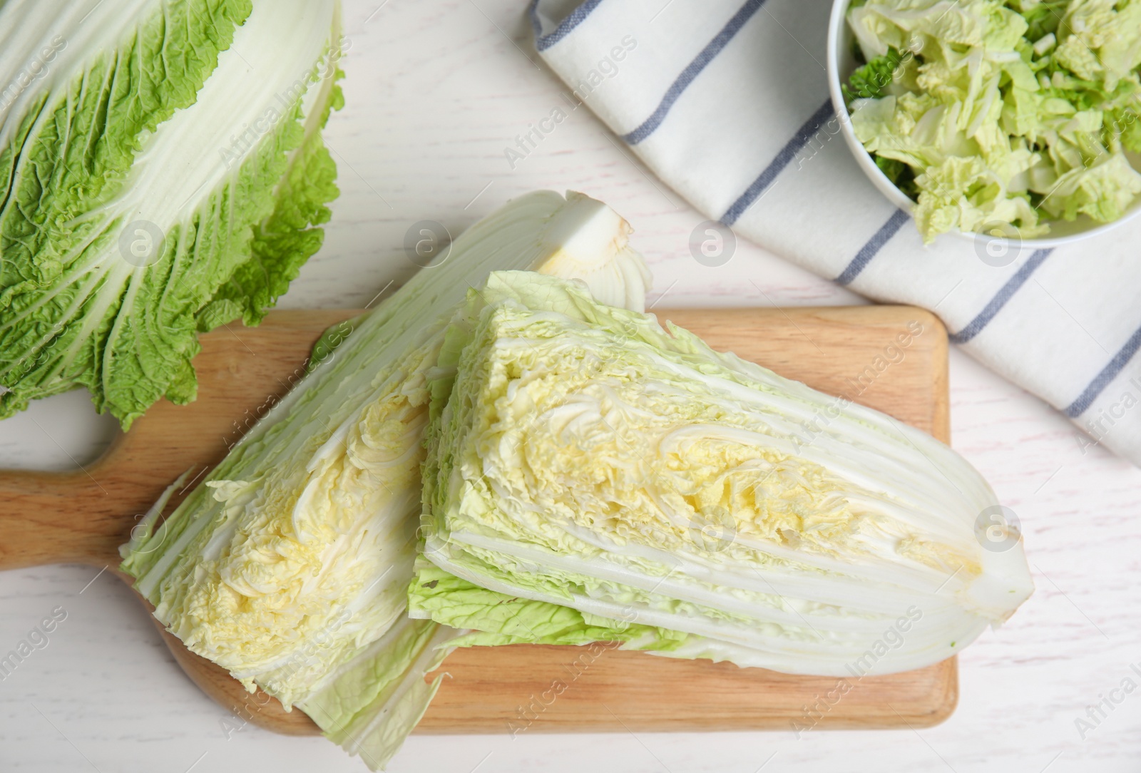 Photo of Delicious cut Chinese cabbage on white wooden table, flat lay