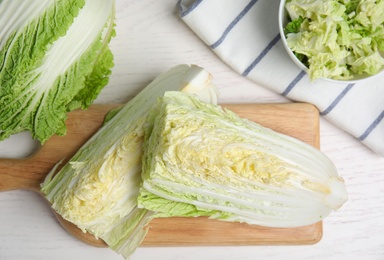 Delicious cut Chinese cabbage on white wooden table, flat lay