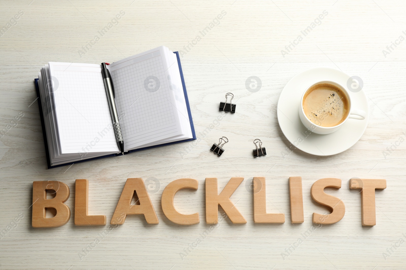 Photo of Word Blacklist of letters, cup with coffee and office stationery on white wooden desk, flat lay