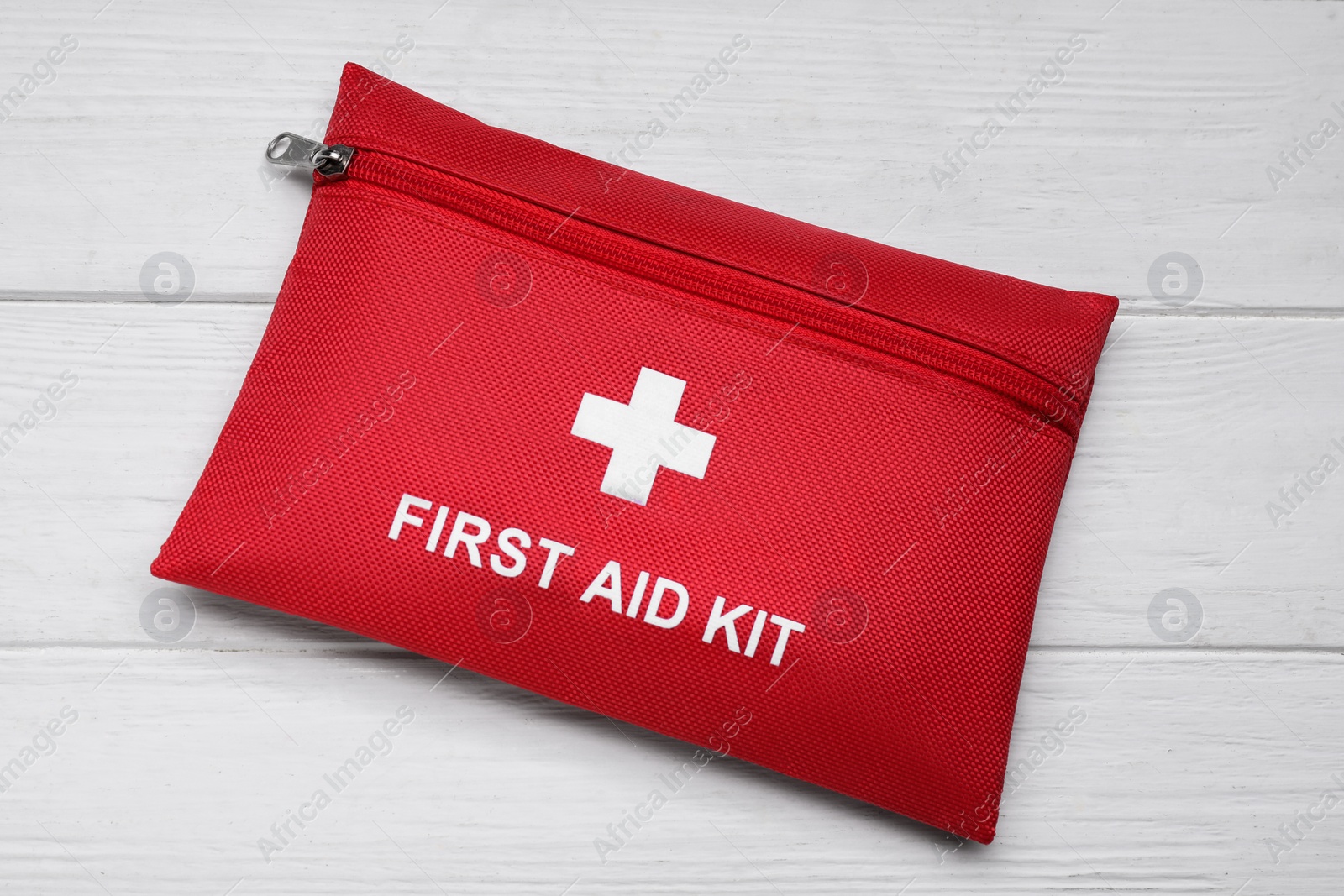 Photo of Medicine bag on white wooden table, top view. First aid kit