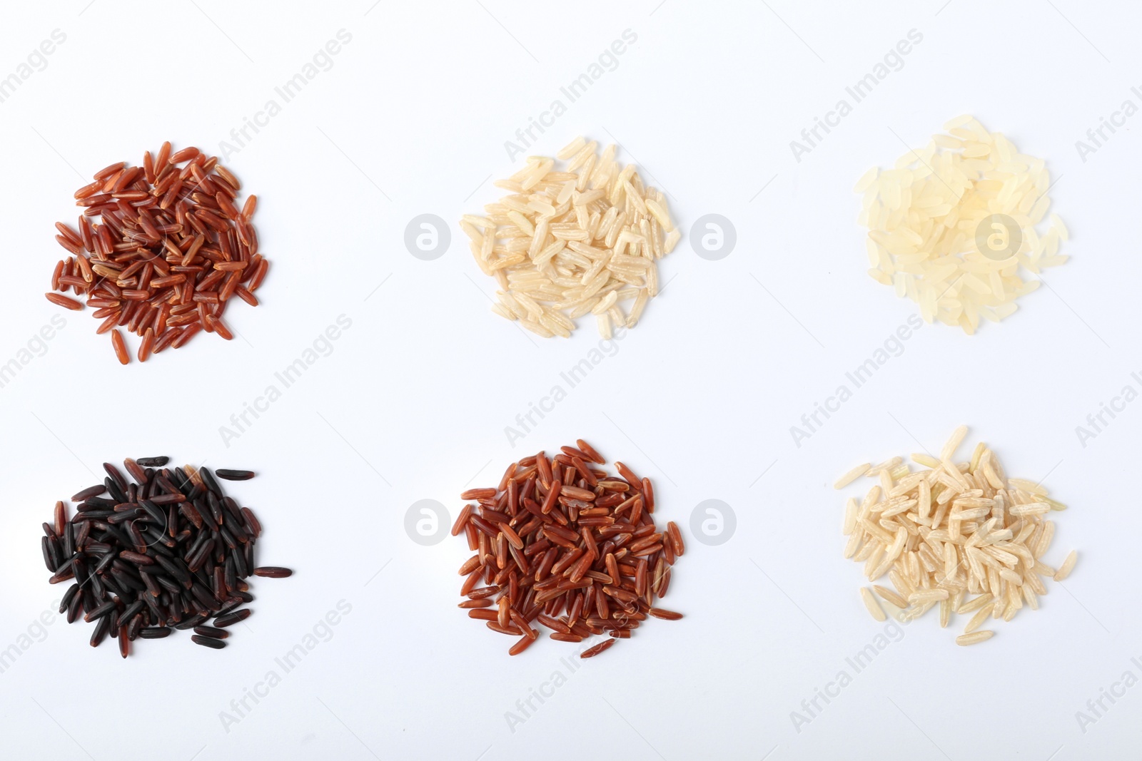 Photo of Different types of uncooked rice on white background, top view