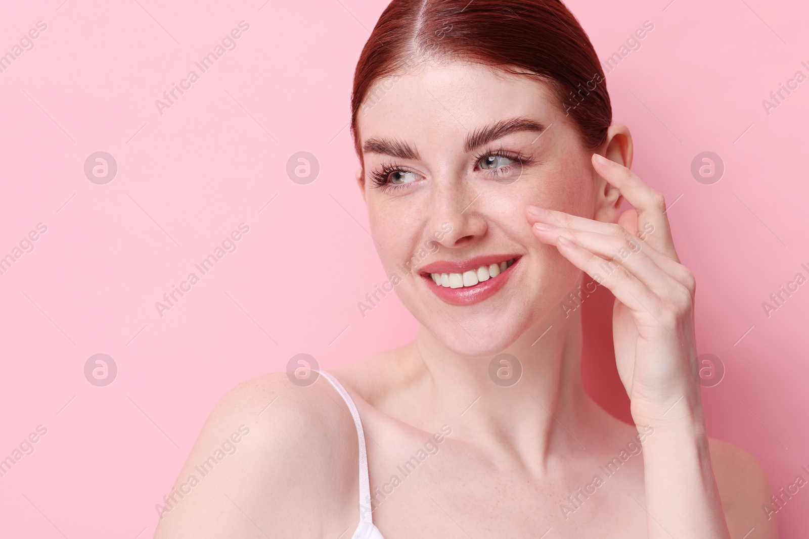 Photo of Portrait of smiling woman on pink background