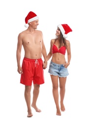 Photo of Happy couple with Santa hats together on white background. Christmas vacation