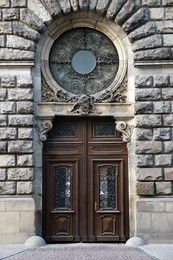 Photo of Entrance of house with beautiful wooden door, elegant moldings and wrought iron decor