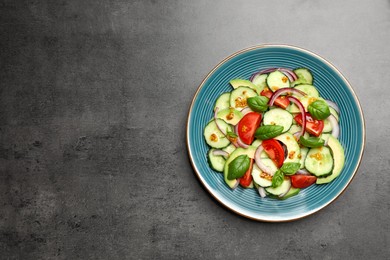 Photo of Tasty salad with cucumbers on grey table, top view. Space for text