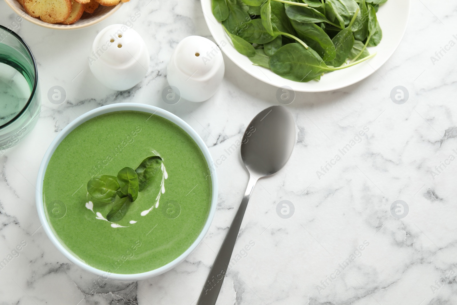 Photo of Flat lay composition with fresh green healthy spinach soup on marble table