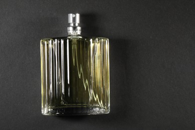 Luxury men`s perfume in bottle on black background, top view. Space for text