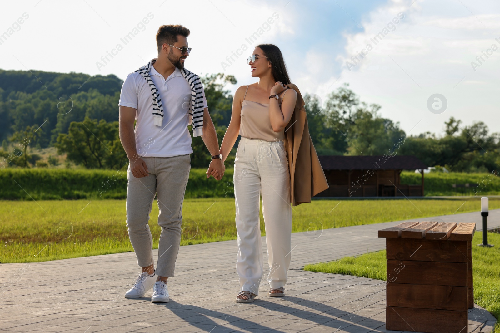 Photo of Romantic date. Beautiful couple walking in park on sunny day