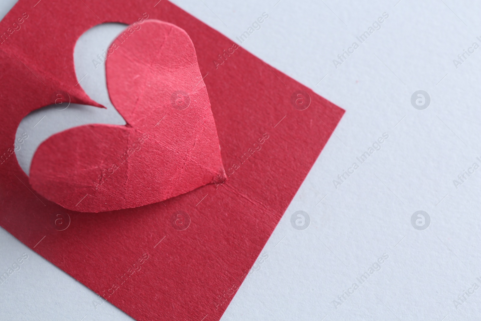 Photo of Red paper heart on gray background, above view. Space for text