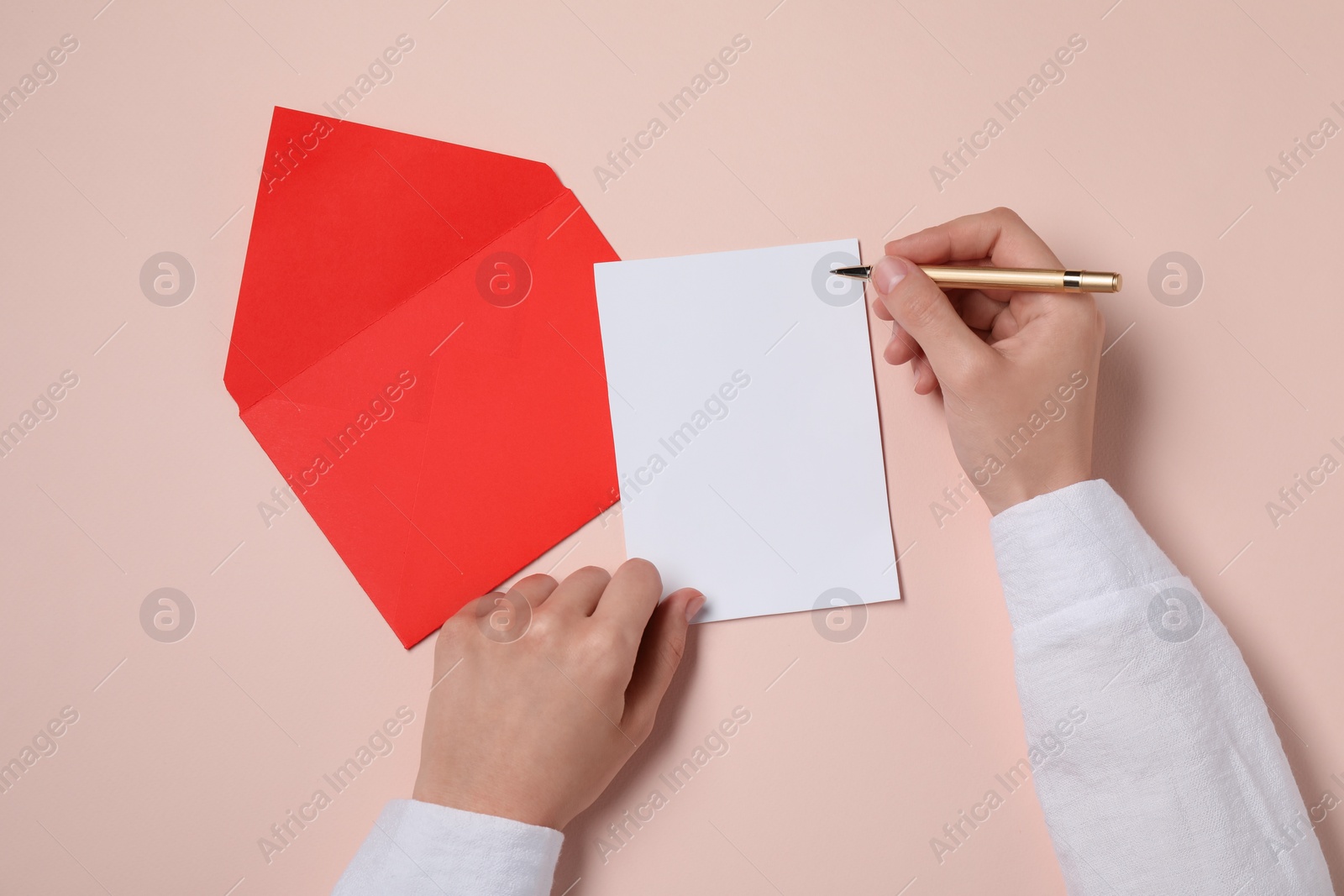 Photo of Woman writing letter at beige table, top view. Space for text