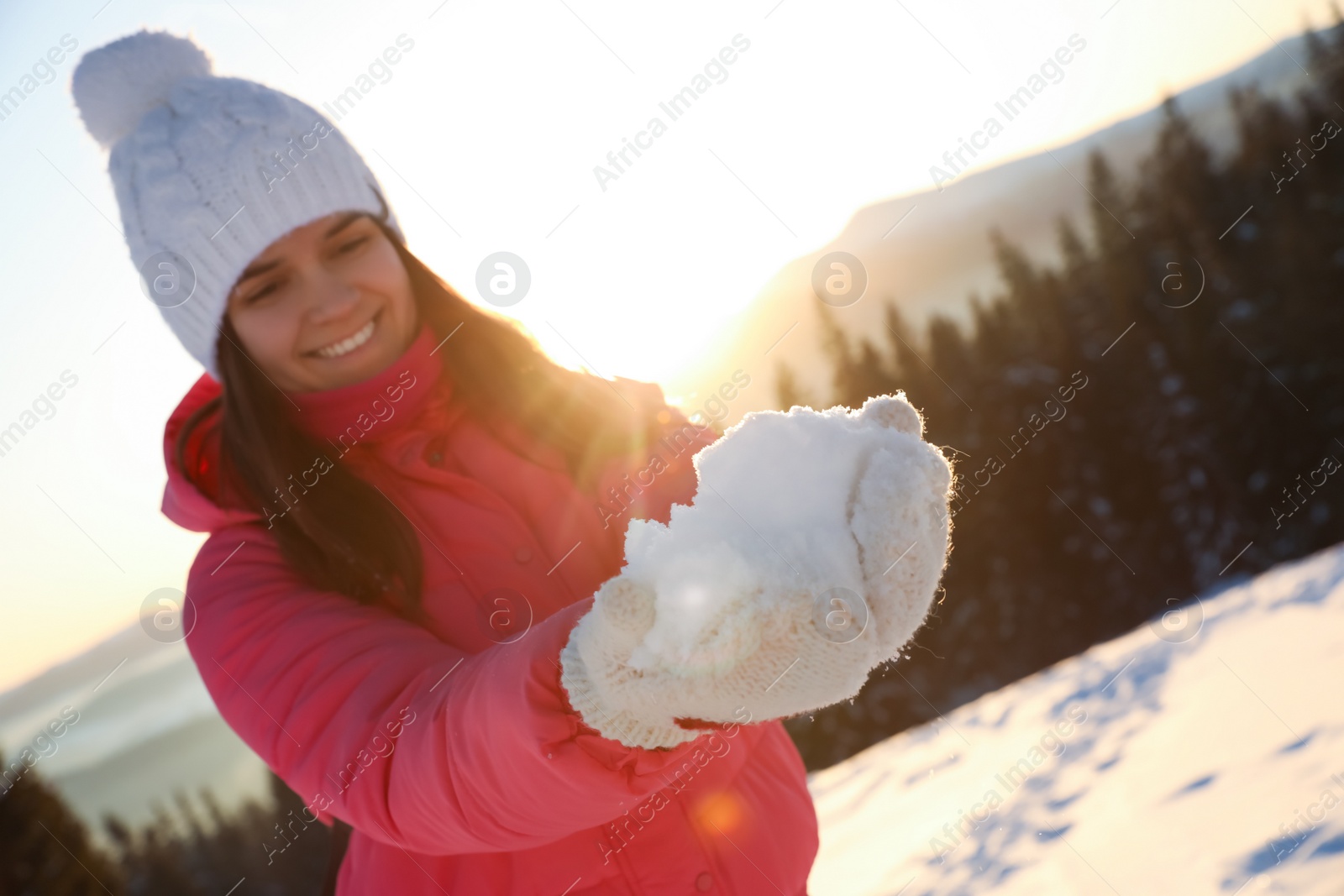 Photo of Woman holding pile of snow outdoors. Winter vacation