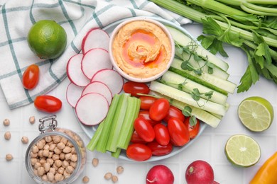 Plate with delicious hummus and fresh vegetables on white table, flat lay