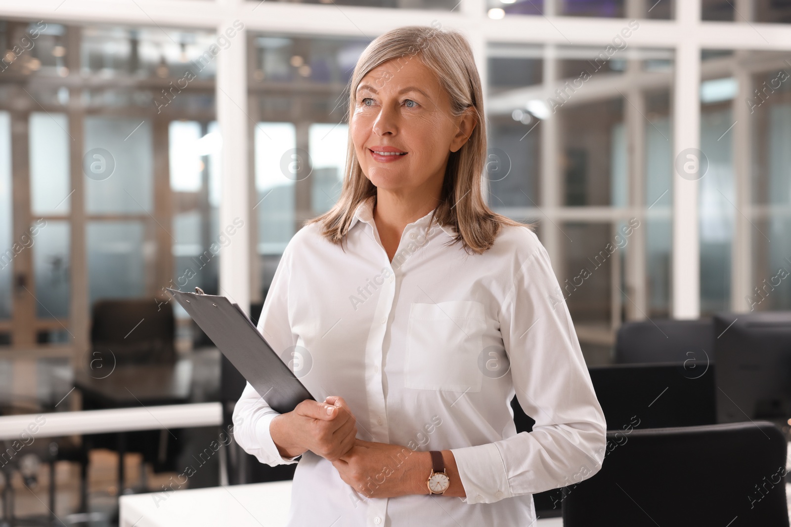 Photo of Smiling woman with clipboard in office. Lawyer, businesswoman, accountant or manager