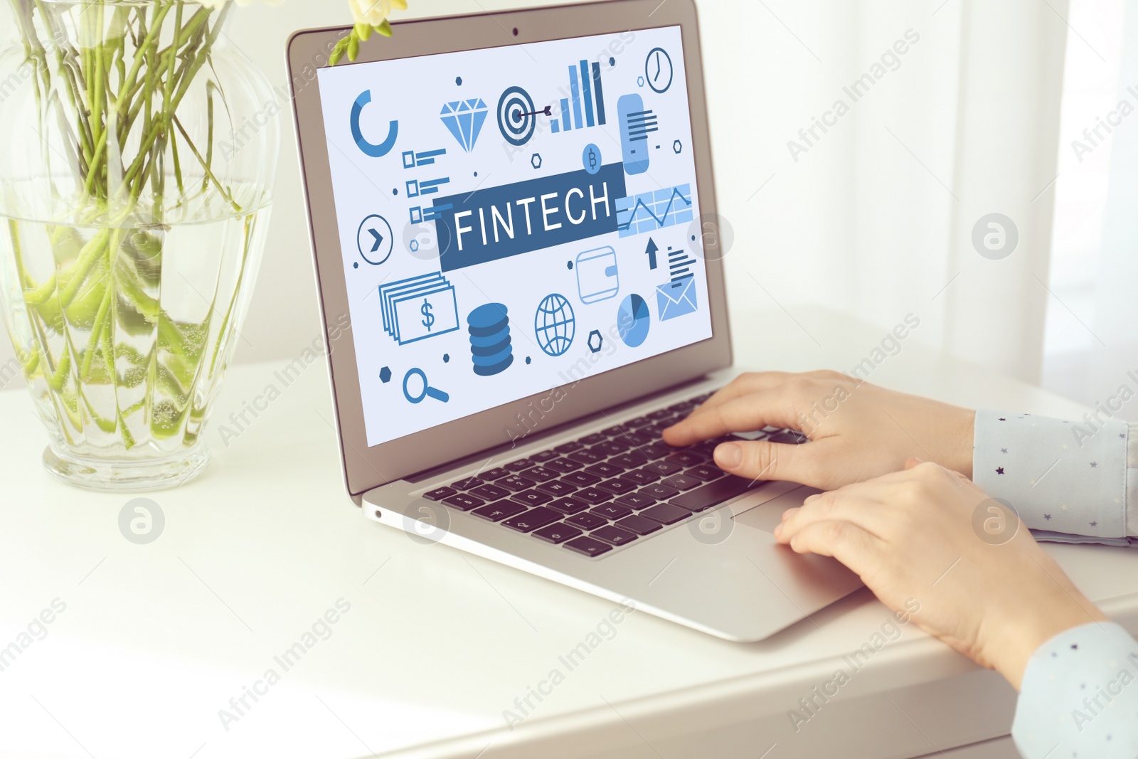 Image of Woman working on modern laptop with word FINTECH at white table indoors, closeup