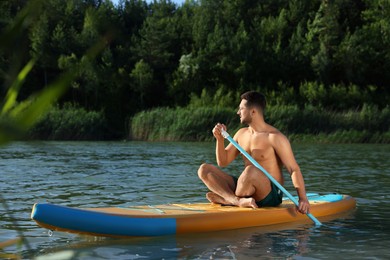 Photo of Man paddle boarding on SUP board in river