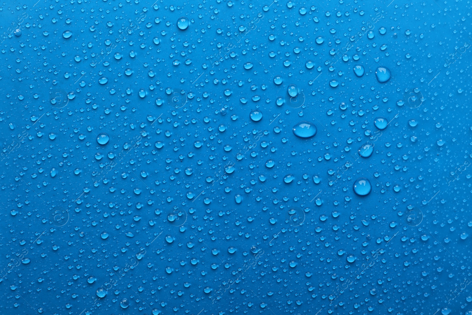 Photo of Water drops on light blue background, top view