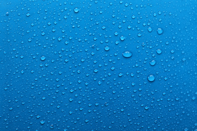Water drops on light blue background, top view