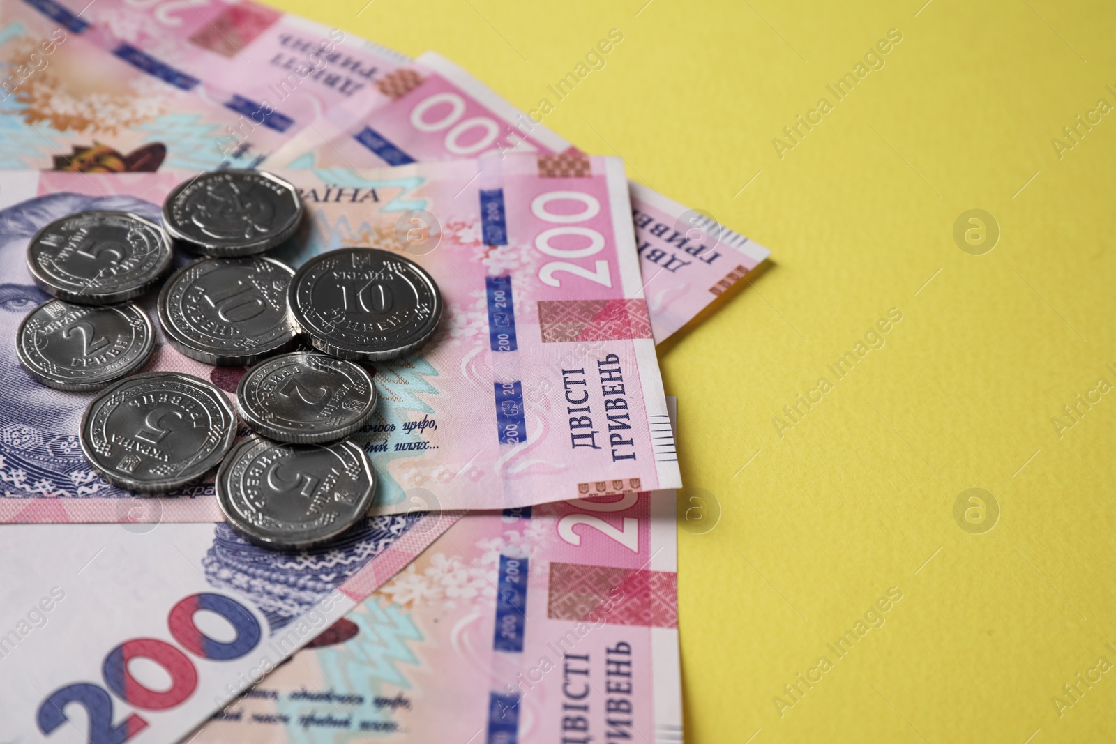 Photo of Ukrainian money on yellow background, closeup. National currency