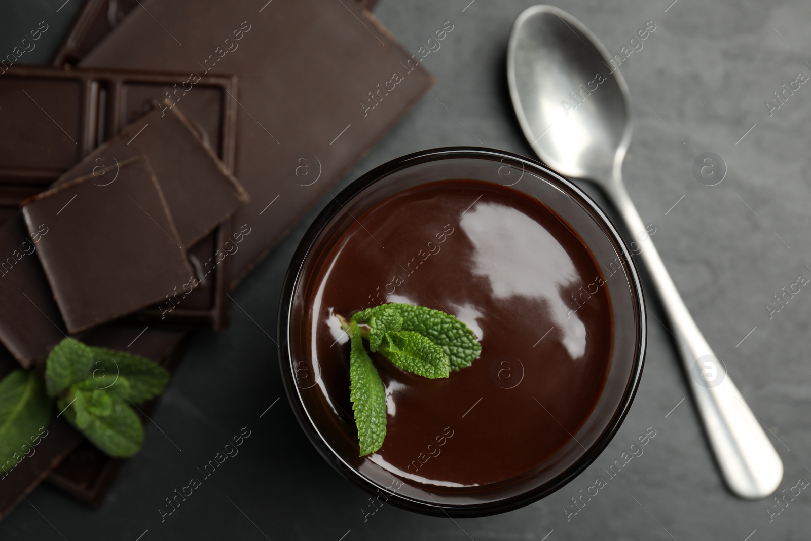Photo of Glass of delicious hot chocolate with mint on dark grey table, flat lay