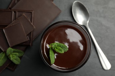 Glass of delicious hot chocolate with mint on dark grey table, flat lay