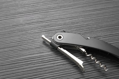 Photo of One corkscrew (sommelier knife) on black wooden table. Space for text