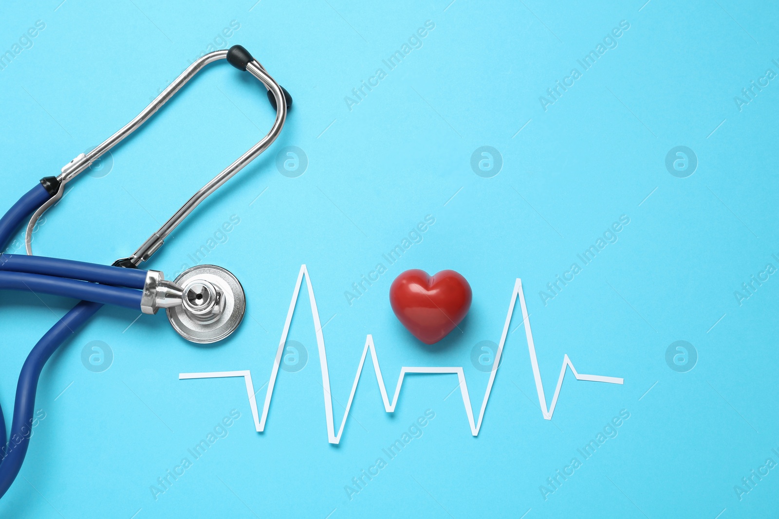 Photo of Paper cardiogram line, red heart and stethoscope on light blue background, flat lay